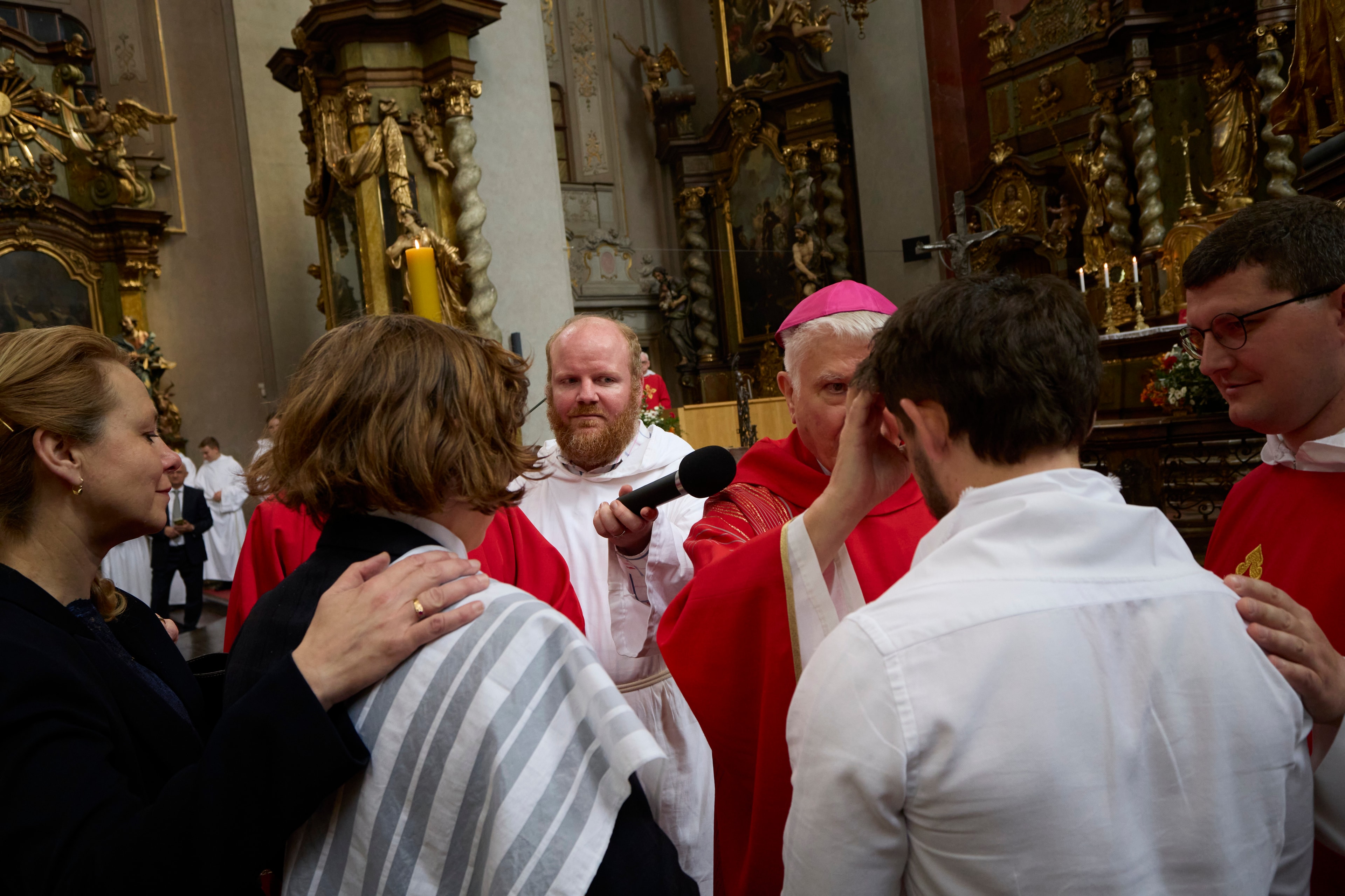 Obřad biřmování zezadu - biskup uděluje svátost pomazáním křížem na čele